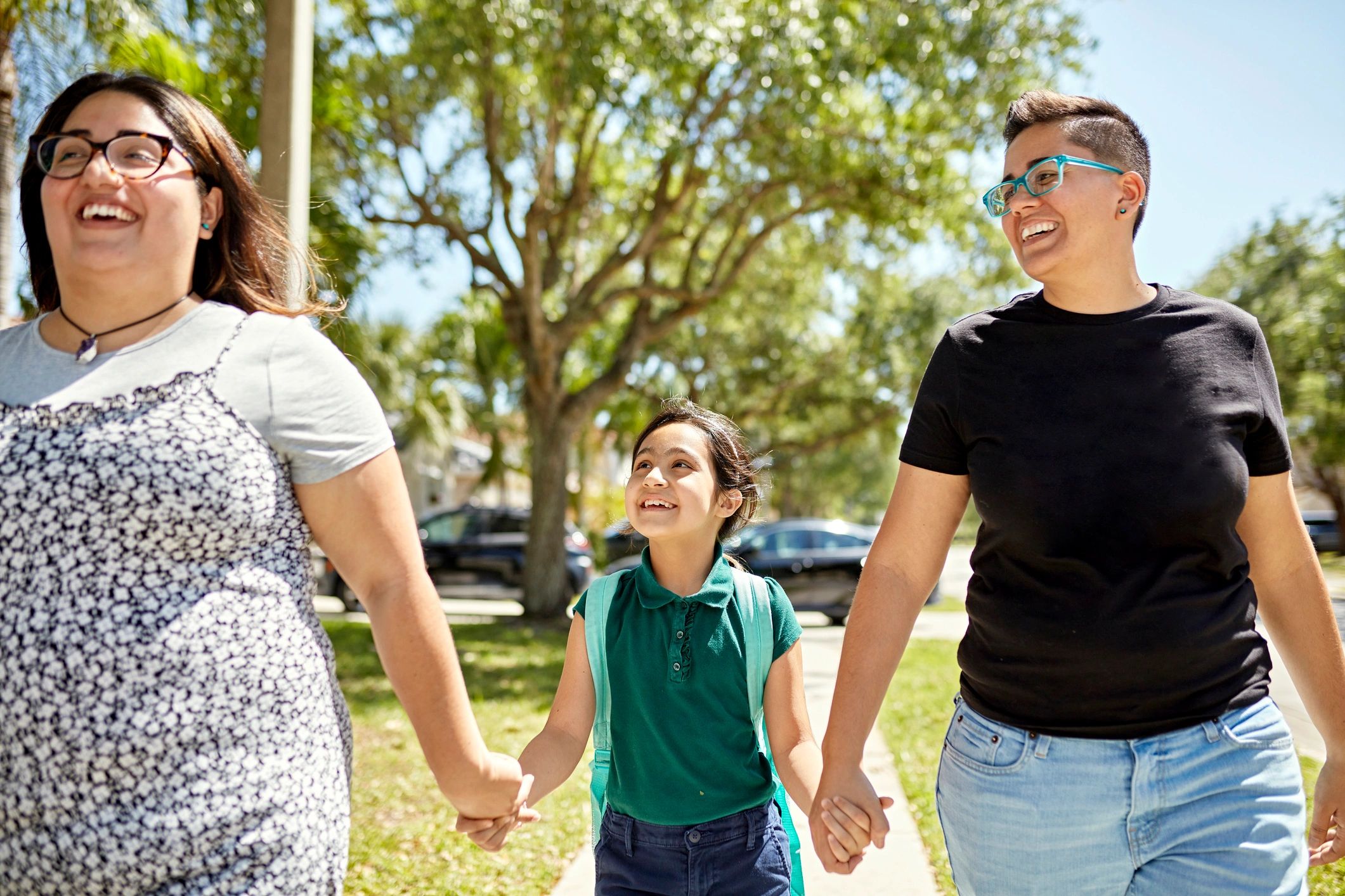 Parents and child walking together near a school